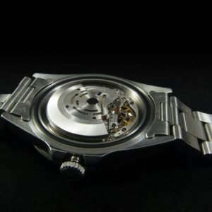 Intricate view of a silver analog watch showcasing detailed gear and mechanism against a black background.