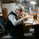 Skilled senior watchmaker using tools to repair watches in a workshop.
